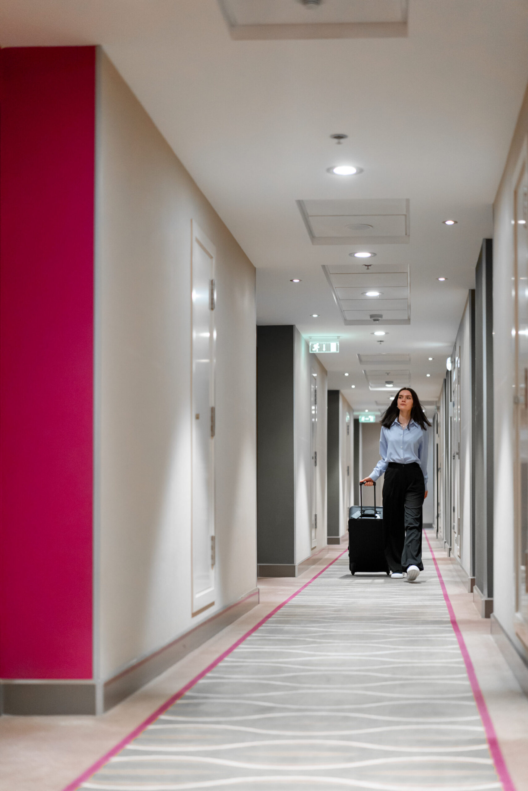 Girl walking down hotel corridor
