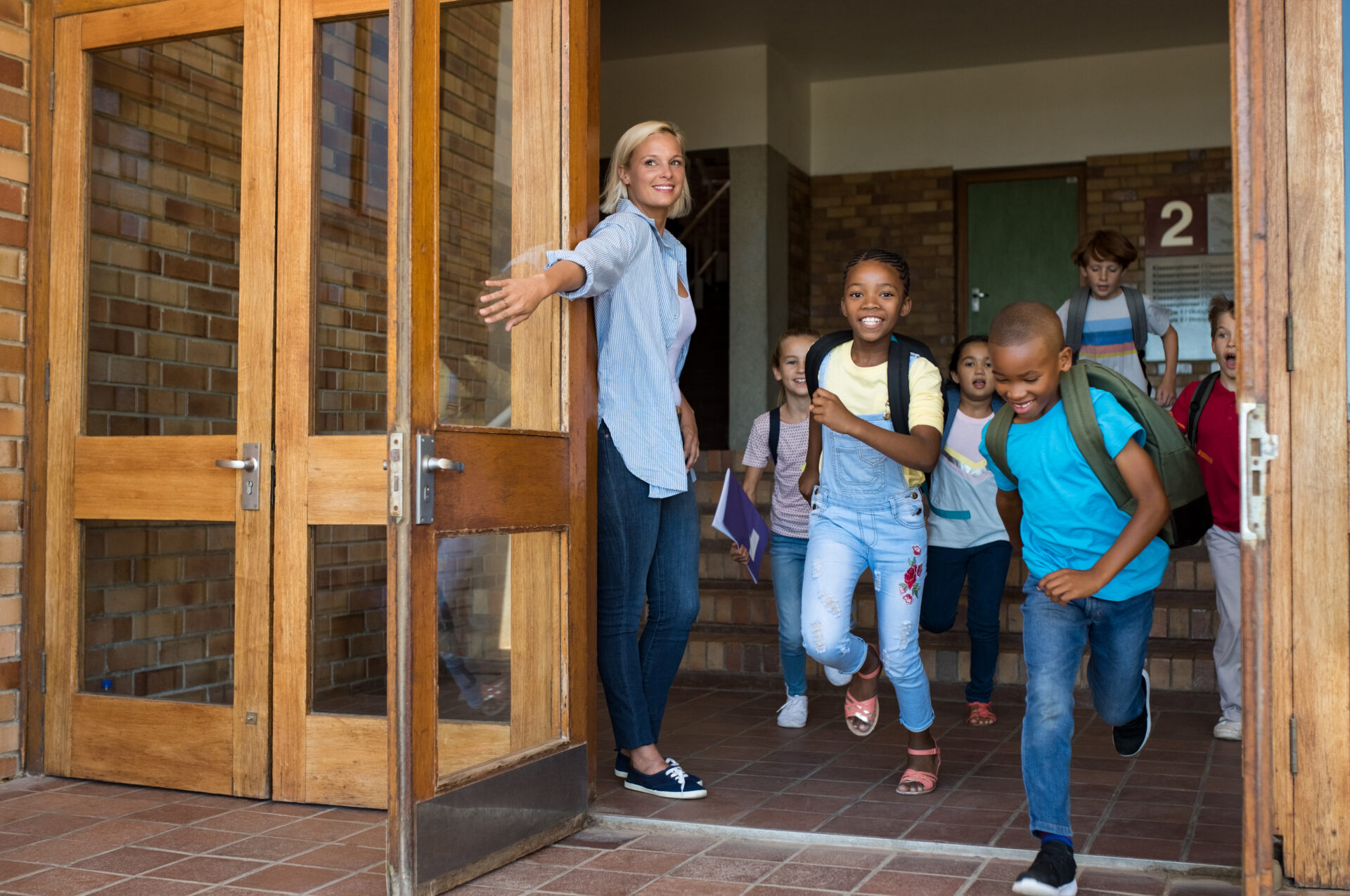 School kids running through fire door happily